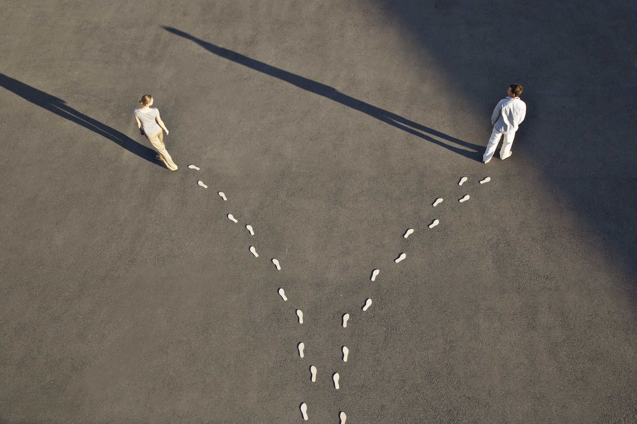 Man and woman walking in opposite directions along separate paths to symbolise a marriage ending without a courtroom battle